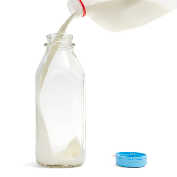Milk Pouring Into Glass Kefir Bottle